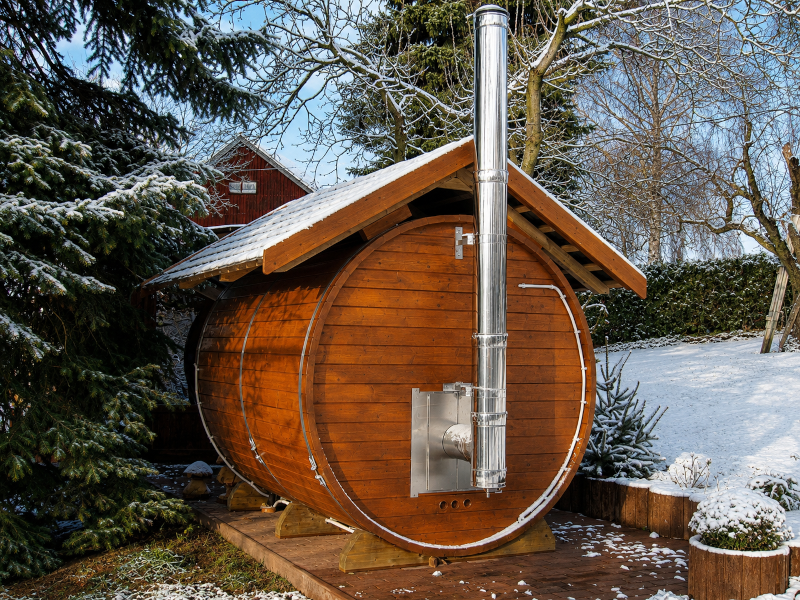 Fasssauna mit Schornstein des Holzofens in winterlicher Umgebung