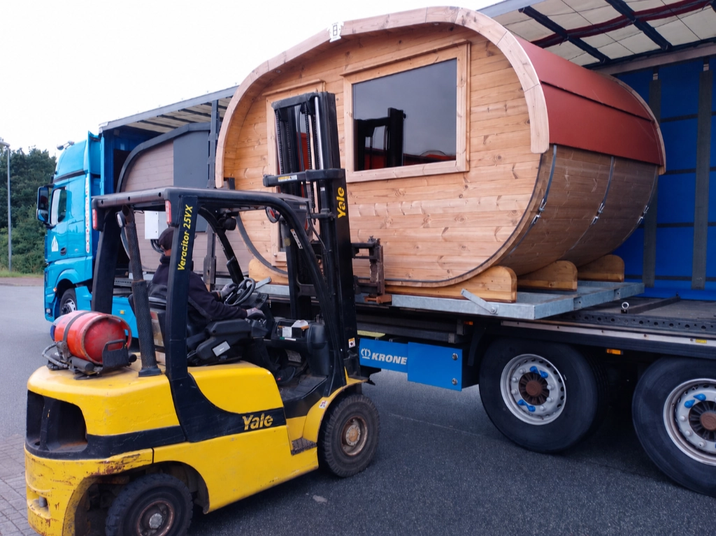 Fasssauna wird per Gabelstapler vom Lkw für den Messetransport verladen